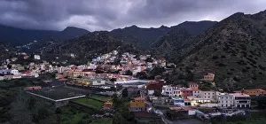 View of Vallehermoso and the surrounding mountain landscape at dusk under a cloudy sky