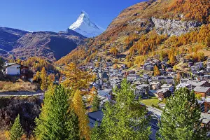 View of the village with Matterhorn 4478m and golden yellow larches in autumn
