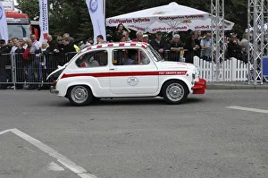 Side view of a white small vintage car at a race