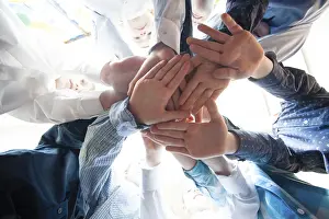 Bottom view of young boys putting their hands together as a symbol of friendship