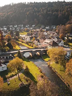 Village in autumn with river, bridge and colourful nature