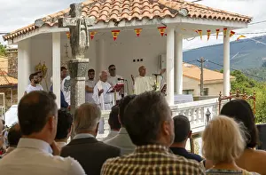 Village fiesta Catholic priest praying at outdoor mass service