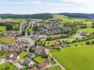 Village in a hilly, rural setting with scattered houses and green fields