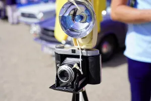 Vintage camera with flash unit and tripod at an event