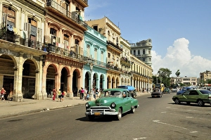 Vintage car in front of buildings with colourful facades