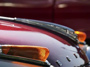 Detail of a vintage car with red paintwork and chrome accents