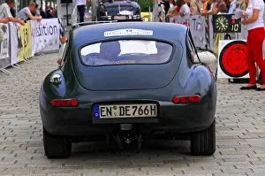 Vintage green jaguar car seen from behind with spectators at an event