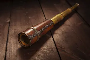 Vintage retro spyglass on wooden background