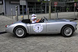 Vintage silver convertible car with people in a vehicle