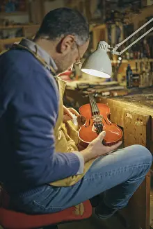 Violin maker at work carefully crafting a new instrument a luthier's dedication to his craft using traditional