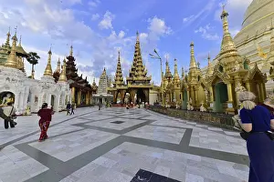 Visitors explore an expansive temple complex under a sunny sky