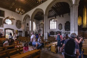 Visitors inside a church with arches