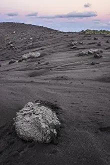Volcanic bombs, lava rock on the edge of the crater of Mount Yasur volcano in the morning light