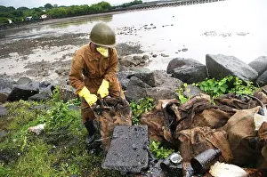Category Historic EN Prints: Volunteer cleaning oil spill garbage at elephanta island