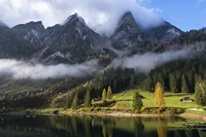 The Vordere Gosausee in autumn with a view of the cloud-covered Gosaukamm