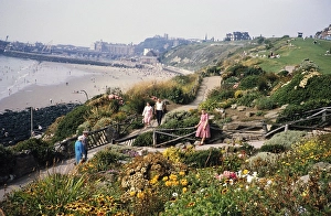 Walkers on the garden paths of the East Cliff rockery, sandy beach in the background, Folkestone, Kent, England, UK 1962