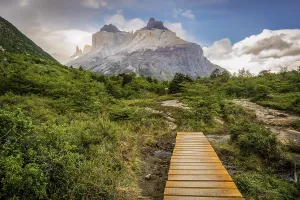 Wanderer beim Ueberqueren einer Holzbruecke