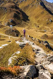 Wanders woman on the way to the summit cross in rocky mountain landscape in autumn