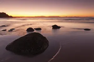 Washed stones and rocks on a beach at sunset in Byron Bay