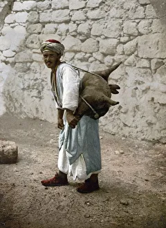 Water carrier, water seller with a goat bellows in Jerusalem