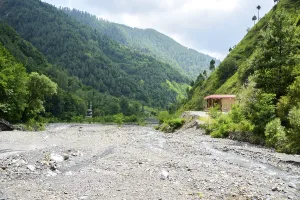 Water flowing over river rocks near mountains in Nathia Gali