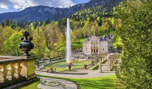 Water parterre with large fountain and portal of Linderhof Castle in spring