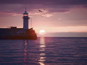 Watercolor style image of lighthouse on sunrise
