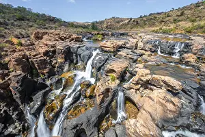 Waterfall on orange-coloured rock cliffs