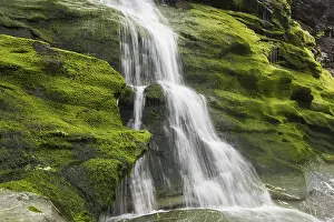 Waterfall on the west coast, water flowing over mossy rocks