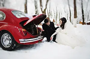 Wedding couple in winter near old vintage car