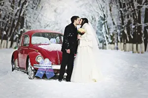 Wedding couple in winter near old vintage car