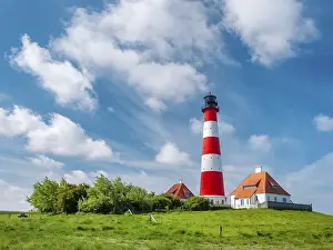 The Westerheversand lighthouse under a blue sky with white clouds