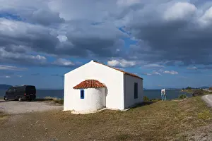 White building with a red roof by the sea