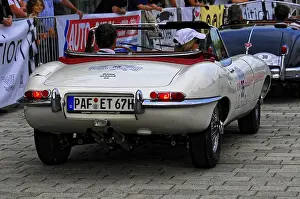 White convertible classic car in a series of classics seen from behind