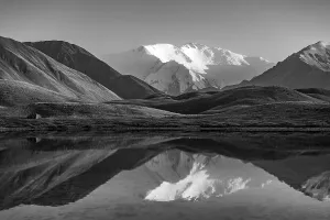White glaciated and snowy mountain peak Lenin Peak at sunset