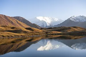 White glaciated and snowy mountain peak Pik Lenin at sunset