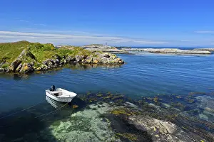 Category Scandinavia Prints: White motorboat anchored in a bay in the rocky coastal scenery at Bud
