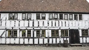 White timbered house, with a bench and rainbarrel in the old town Den Gamle By in Aarhus Denmark