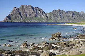 Wide beach with clear blue water and rocks