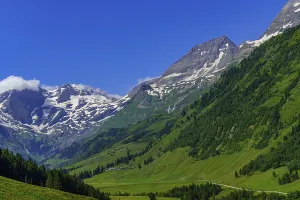 Wide mountain landscape with green valleys and clear sky