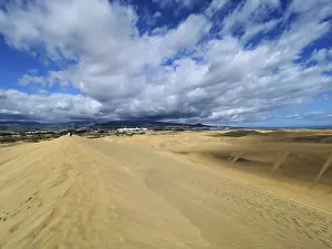 Wide sand dunes under a cloudy sky