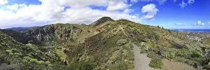Wide view of Bandama crater with surrounding mountains under a cloudy sky