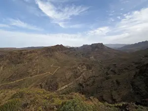 Wide view of a dry, rocky mountain landscape under clear sky