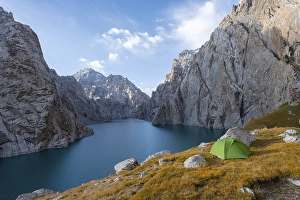 Wild camping, camping in the wilderness with a tent in front of mountain lake Kol Suu