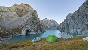 Wild camping, camping in the wilderness with a tent in front of mountain lake Kol Suu