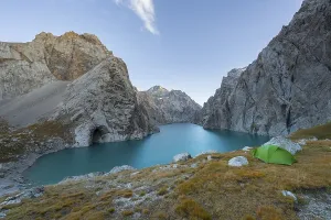 Wild camping, camping in the wilderness with a tent in front of mountain lake Kol Suu
