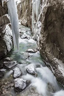 Wild river Partnach in the Partnachklamm with long icicles and snow in winter