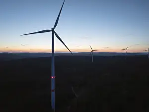 Several wind turbines on the horizon during a sunset