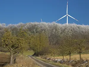Wind turbines, in the middle of a hoarfrost covered forest