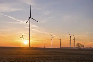 Wind turbines over open fields at sunset